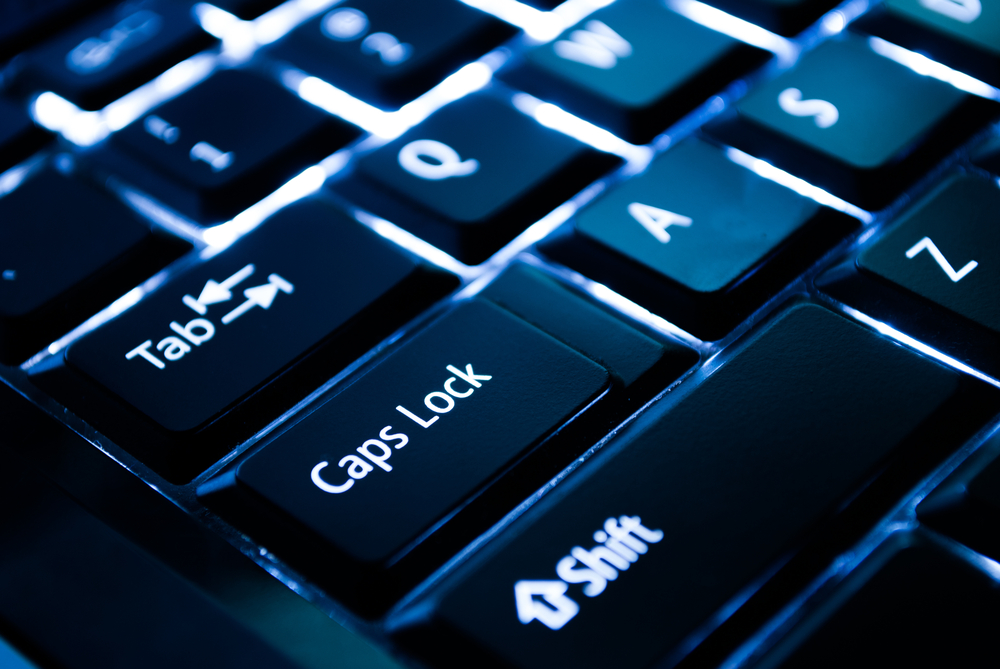 A close-up picture of the tab, caps lock, and shift keys on a black back-lit keyboard with white lettering
