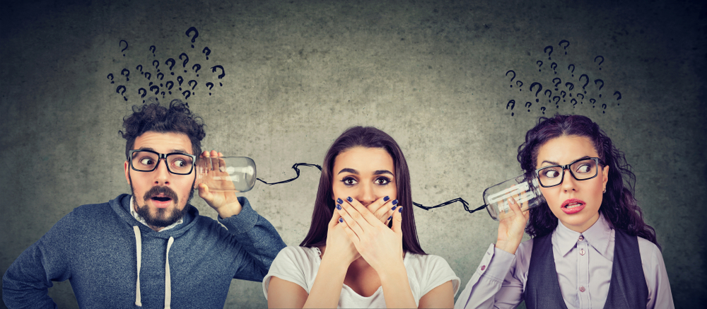 A picture of three people communicating with cups attached to strings looking confused and upset over something they heard