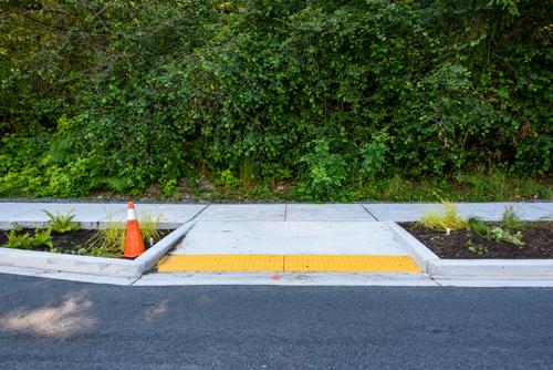 A picture of a curb cut -- a ramp leading from the sidewalk down to the street